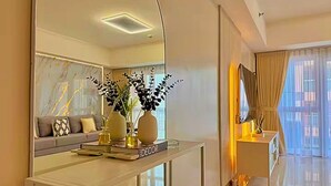 A modern living room with a glass coffee table, a sofa, and decorative vases.