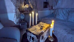 Ein gemütliches Schlafzimmer mit einem Bett, einem kleinen Tisch mit Kerzen und einem dekorativen Globus.