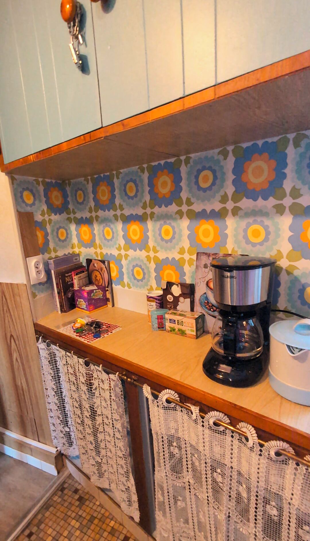 A kitchen with a coffee maker, a kettle, and various kitchen items on the counter.