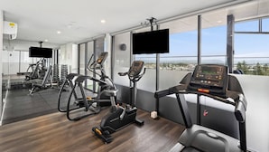 A modern gym with treadmills, elliptical machines, and weightlifting equipment. - Skyline Serenity - Modern Escape + Stunning Views (Surfers Paradise)