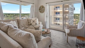 A spacious balcony with a ceiling fan, a sofa set, and a chair.