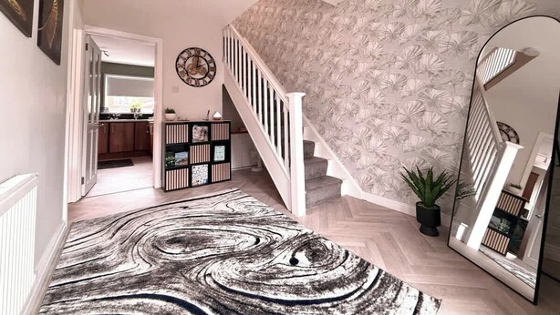 A staircase with a floral wallpaper, a mirrored wall, and a herringbone-patterned rug. - 3BR Modern House, Garden, Parking, Sleeps 6, Wifi (Strabane)