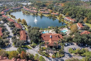An aerial view of a residential area with a lake, a swimming pool, and a fountain. - Bright 3B w/ Pool Close to Disney @ Encantada 8545 (Kissimmee)