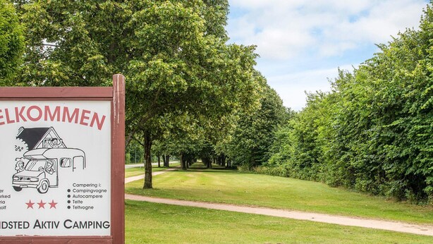 A welcome sign for a camping area with a path leading through a green landscape. - 6 Person Holiday Park Home in Grindsted (Grindsted)