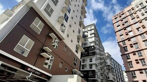 A multi-story residential building with a mix of balconies and windows, an 'EXIT ONLY' sign, and a clear sky. - Cozy Condo @ Paranaque near NAIA (Paranaque City)