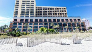 A multi-story hotel with a modern design, featuring a flat roof and a large number of windows.