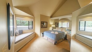 A bedroom with a large bed, a window seat, a desk, and a mirror. - River Ridge 423B - Hospitality Suite Studio (no kitchen), Seasonal Community Pool /Hot Tub (Bend)