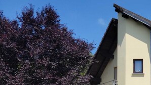 Ein zweistöckiges Gebäude mit Balkon, einer Tür und einem Fenster.