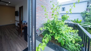 Ein Balkon mit Ziegelwand, einem Tisch mit Stühlen und einem Blumentopf.
