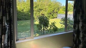 A room with a large window overlooking a garden.