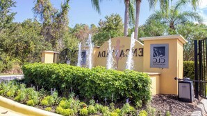 A hotel entrance with a water feature, a sign with the hotel's name, and a logo. - Bright 3B w Pool Close to Disney Encantada 8545 (Kissimmee)