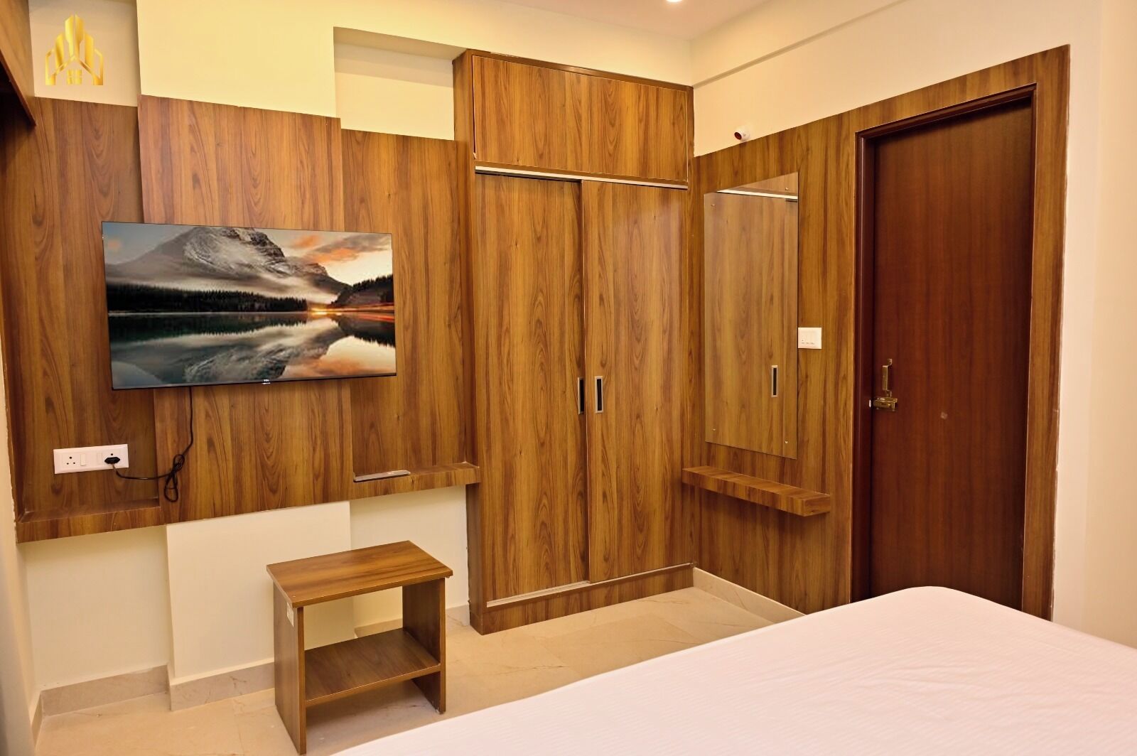 Un dormitorio con armarios de madera, una cama, una mesita de madera y un cuadro en la pared.