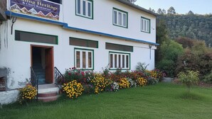 Un edificio de dos pisos con un letrero que dice Nauling Heritage Hotel & Restaurant.