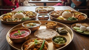 Una mesa de comedor con diversos platos y una vista montañosa.