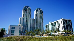 A high-rise hotel with multiple floors, a modern architectural design, and a clear blue sky.