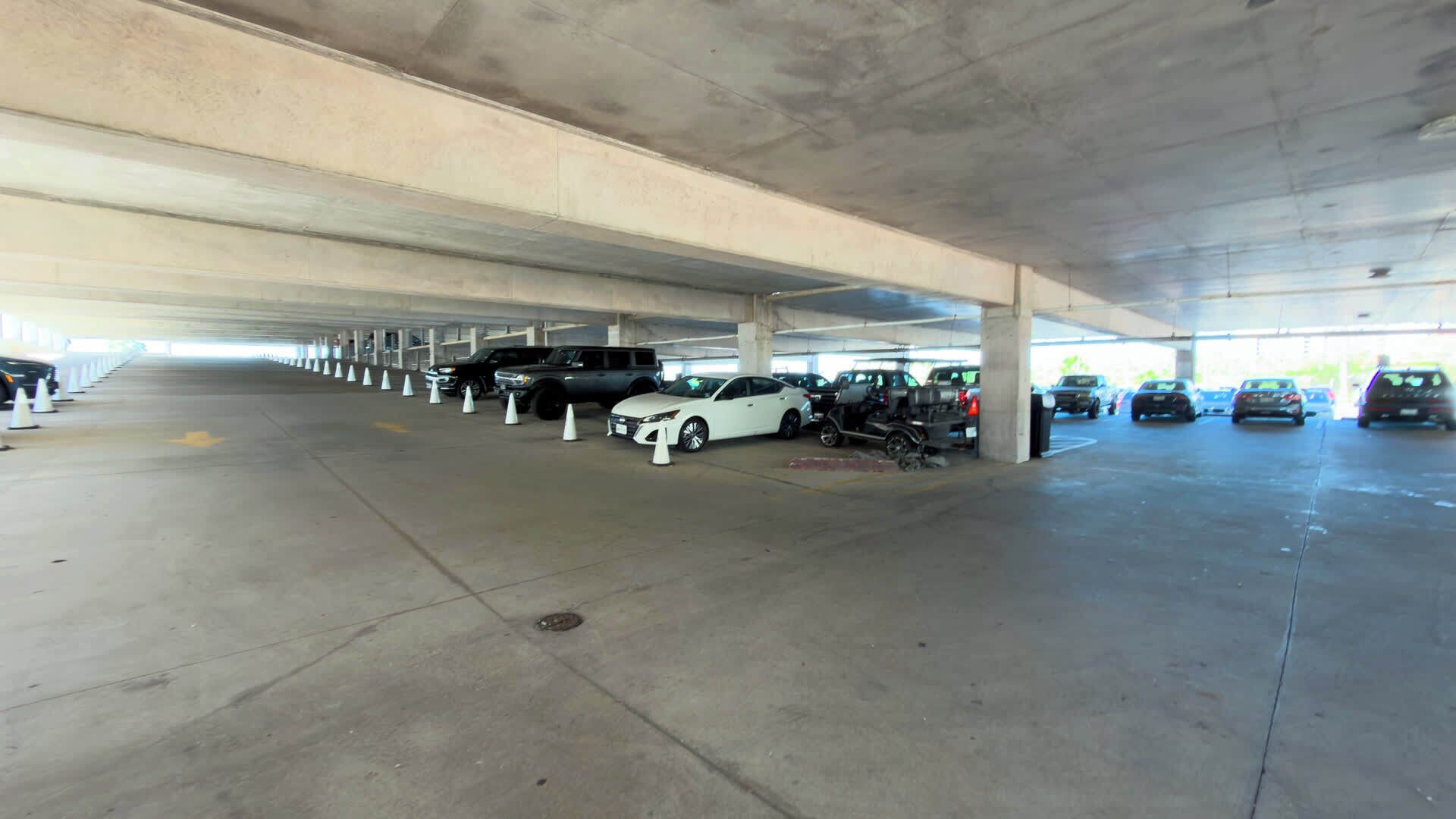 A multi-level parking garage with several cars parked under the overhang.