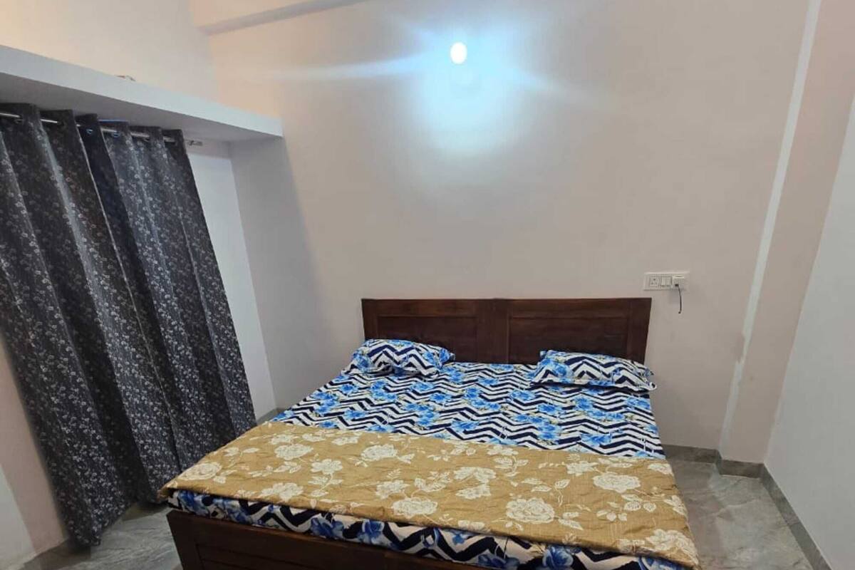 Un dormitorio con cama, cortinas y ventilador de techo.