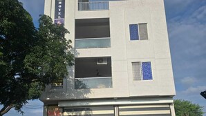 A modern hotel with a flat roof, a garage, and a staircase leading to the entrance.