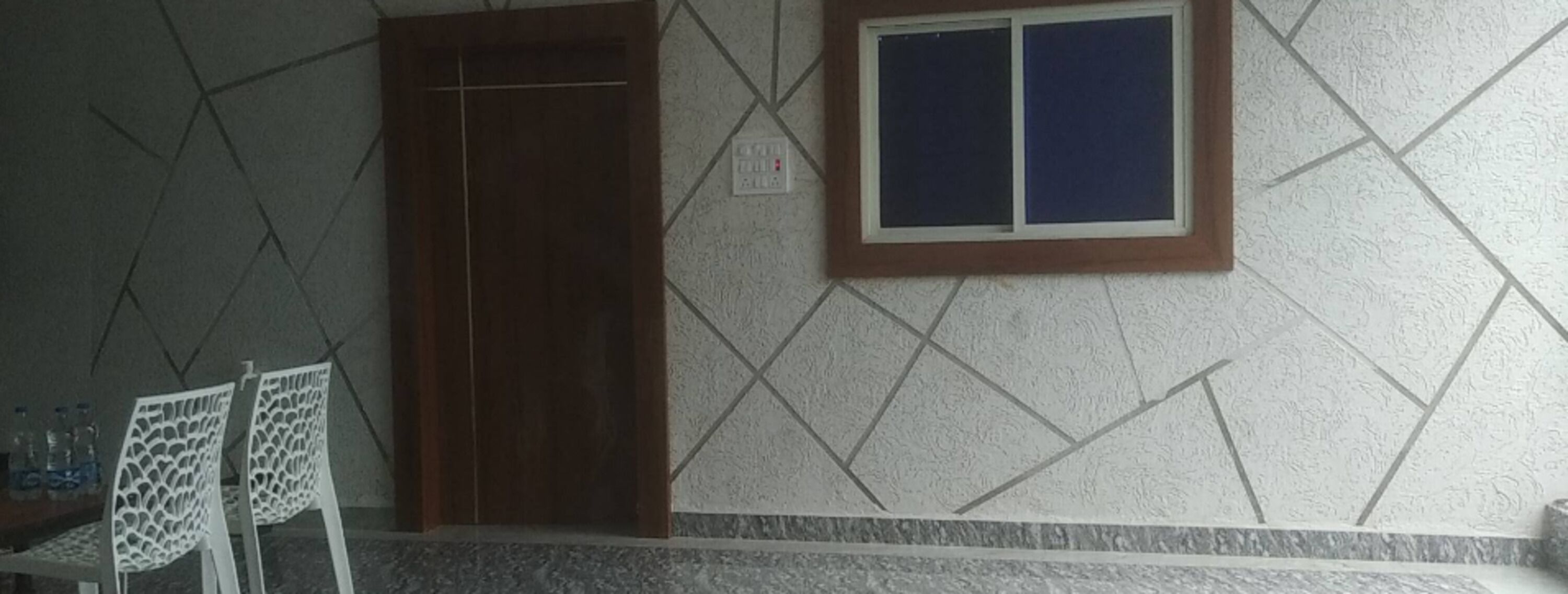 Um quarto com parede de azulejos, porta de madeira e janela com moldura de madeira.