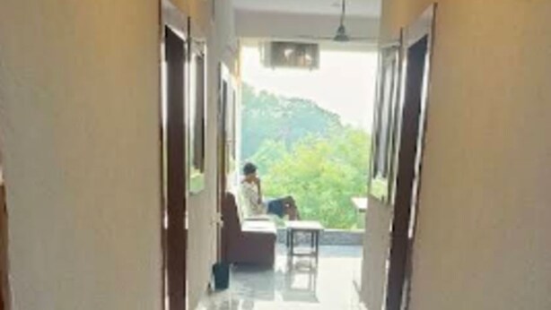 A hallway with a polished granite floor leading to a balcony with a view of greenery.