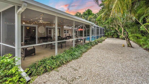 A modern house with a covered patio, outdoor seating, and a pool. - Gulf Gate Dream 2bd 2ba Htd Pool Beaches Shopping (Sarasota)