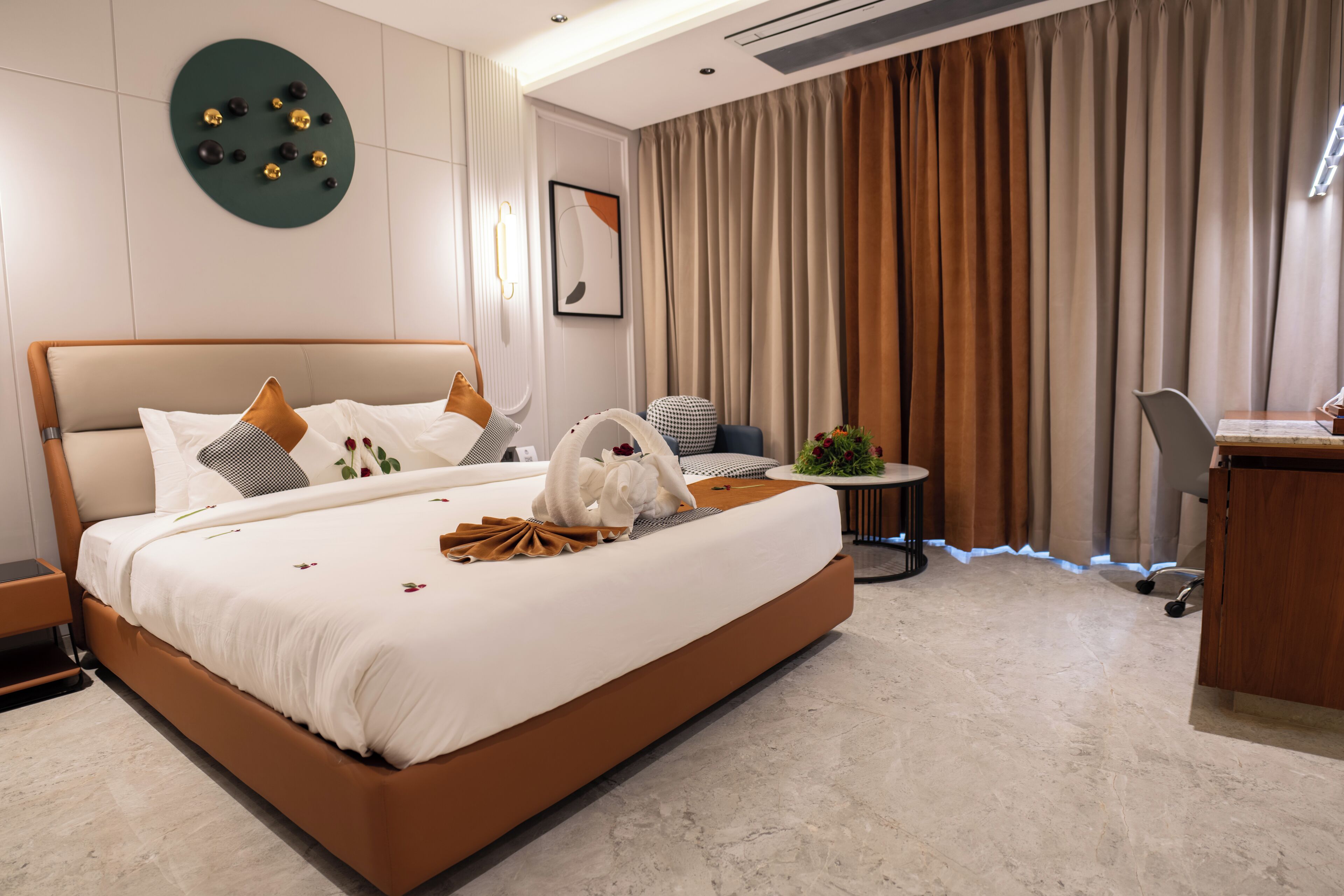 A modern hotel room with a large bed, a desk, and a chair.