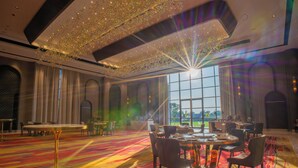 A spacious room with a large round table, multiple chairs, and a view of the outdoors through large windows. - AMARTARA THE RESORT (Abu Road)
