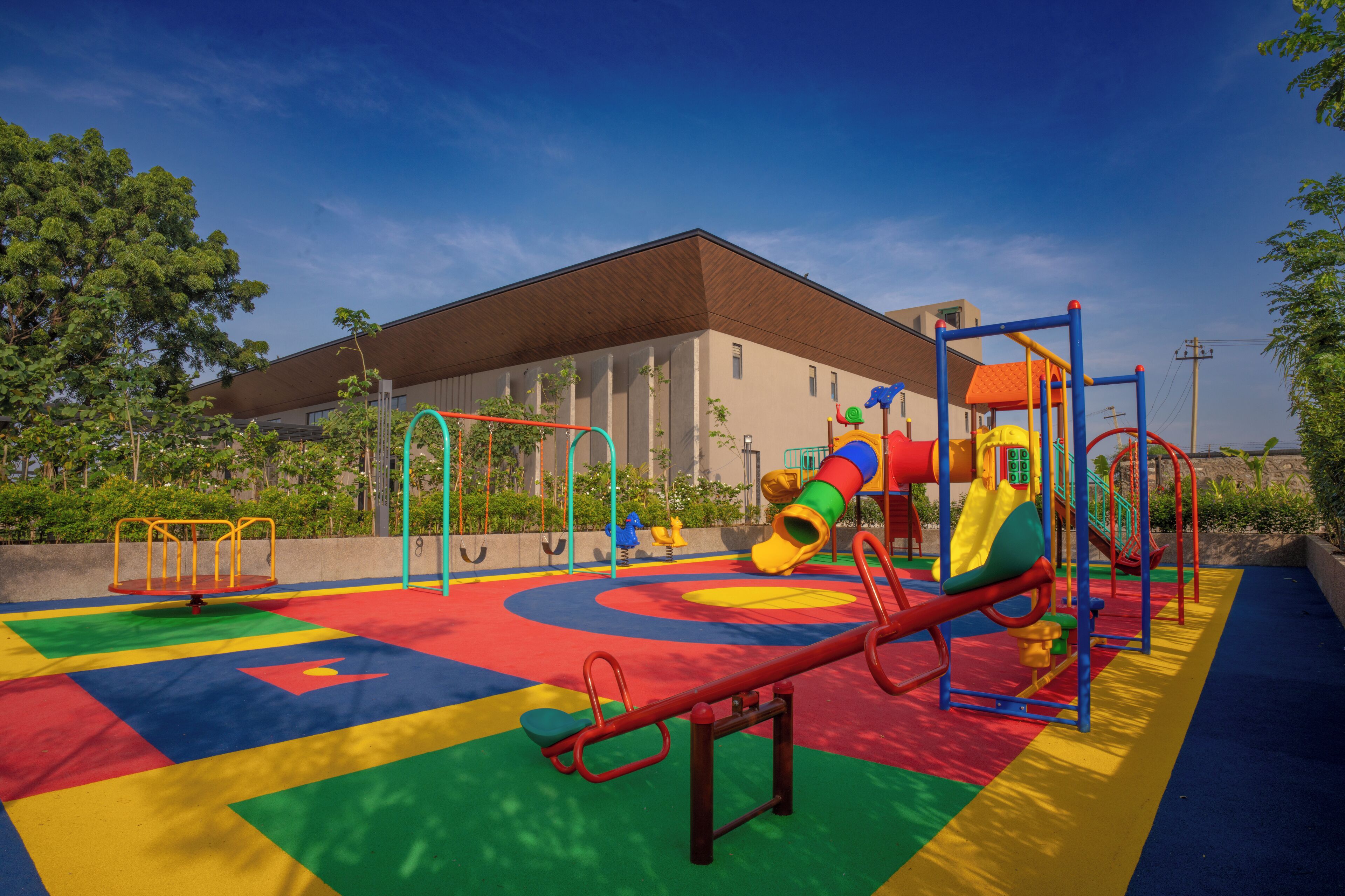 Un parque infantil con diversas estructuras de juego, como un sube y baja, un tobogán y juegos de escalada.