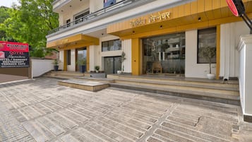A hotel with a modern facade, featuring a signboard for a restaurant and a Qotel.