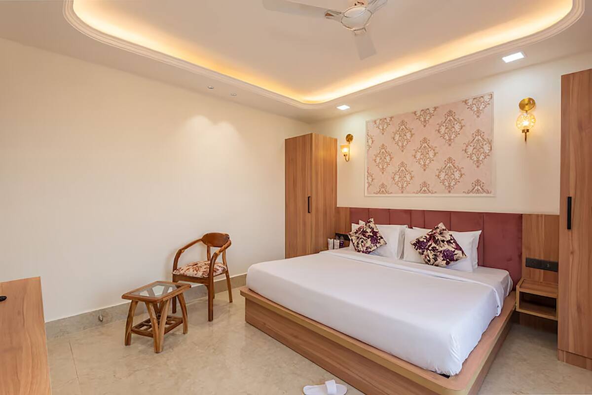 Un dormitorio moderno con una cama grande, muebles de madera y un panel decorativo en la pared.