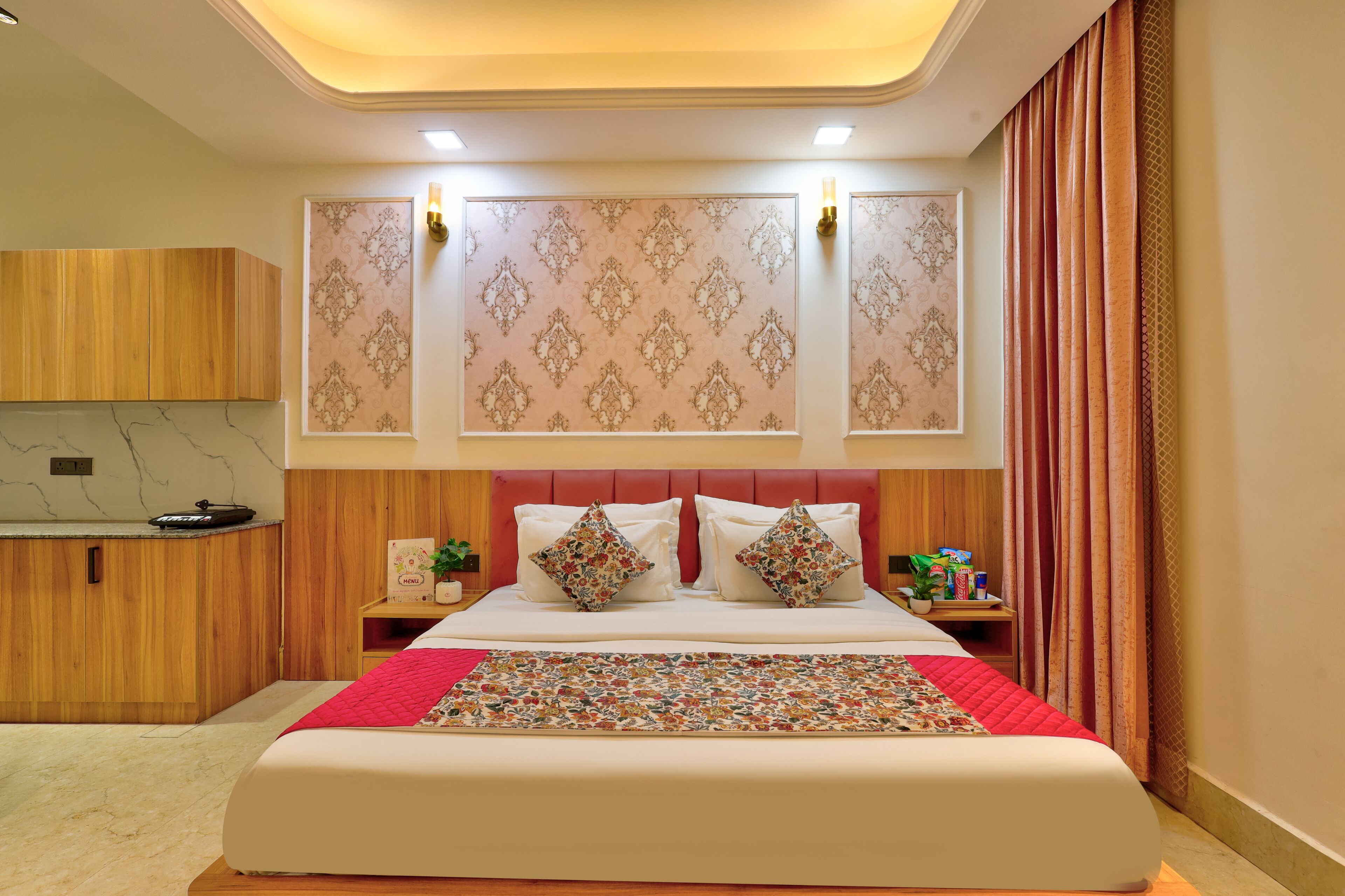 Habitación de hotel con cama, armario de madera, mesita de noche, luz de pared y cortina.