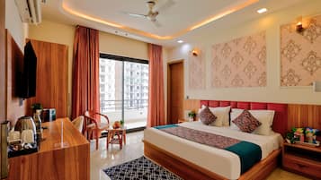 A hotel room with a bed, a desk, a chair, a TV, and a window with curtains.