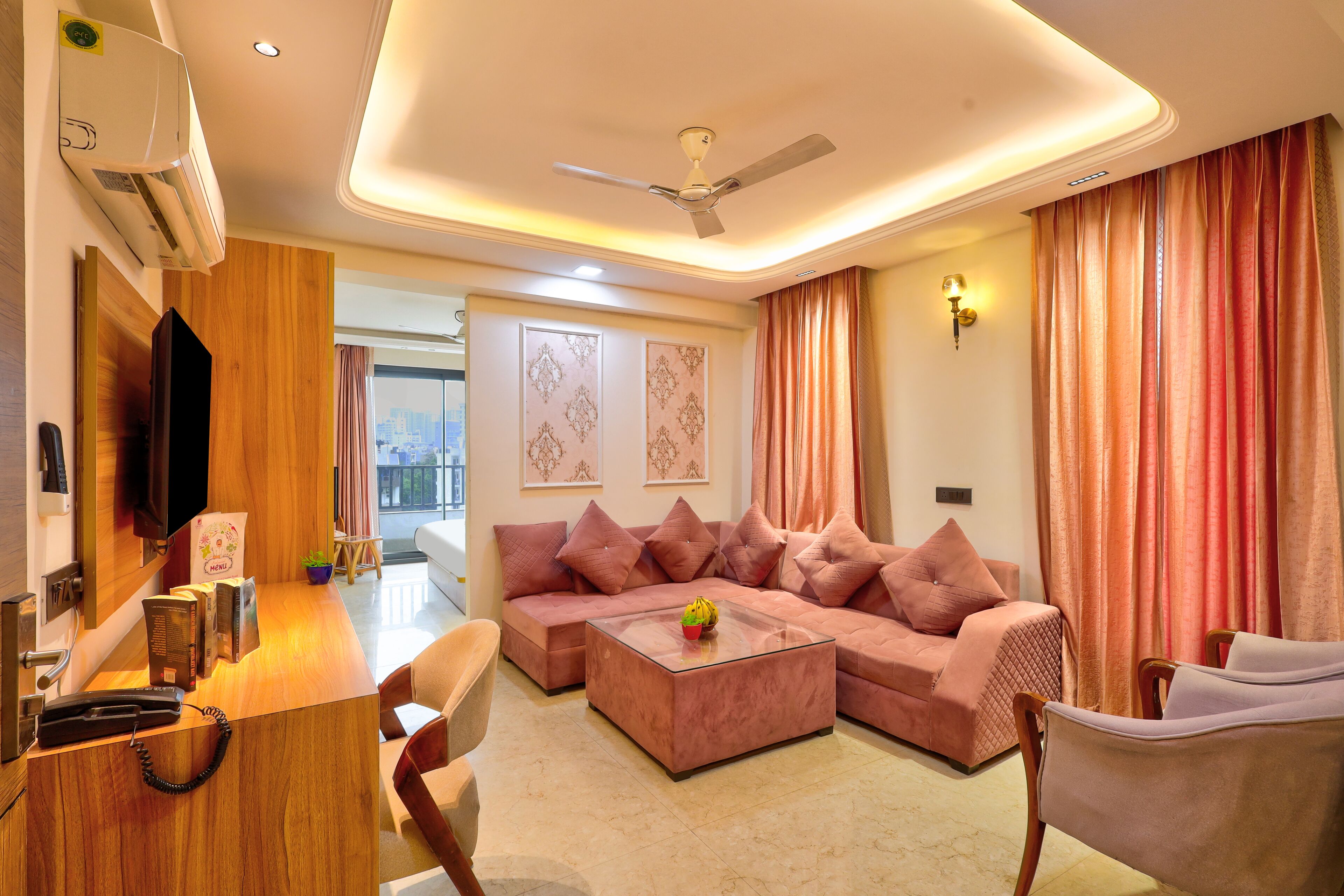 A modern living room with a sectional sofa, a coffee table, a TV, and a ceiling fan.
