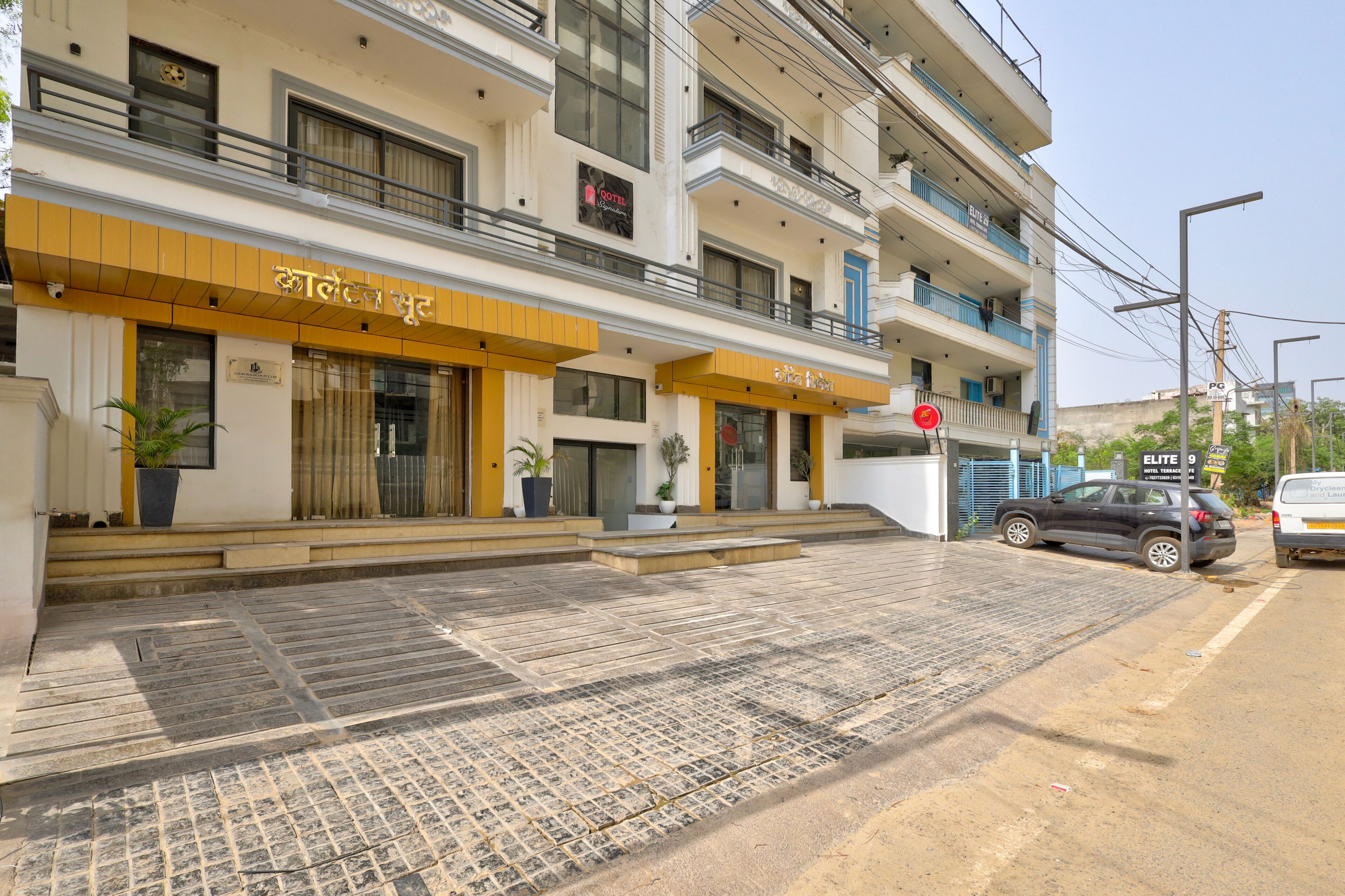 A hotel entrance with a yellow awning, a sign for 'HOTEL TERRACE,' and a red stop sign.