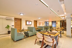 A hotel lobby with seating areas, a reception desk, and a sign indicating the hotel name.