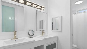 A modern bathroom with two sinks, a mirror, and a shower area. - Studio w/ King Bed & Balcony (Palmas del Mar)