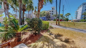 A residential area with palm trees, a pathway, and a building with balconies.
