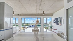 A modern kitchen with large windows, a central island, and a view of the outdoors. - Luxe Studio @ Atlantis | 5 Min to Old San Juan (San Juan)