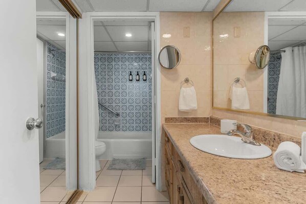 A bathroom with a bathtub, a sink, and a mirror.