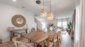A spacious dining area with a wooden table, wicker chairs, and pendant lighting. - 2405 E 19th Ave Summa (Tampa)