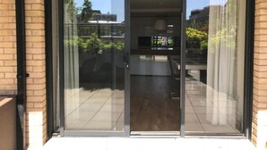 A modern sliding glass door leading to a balcony with a view of the cityscape.