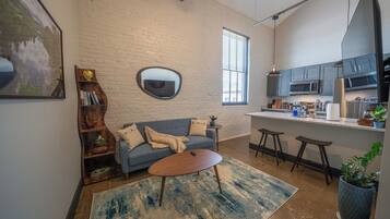 A modern living space with a sofa, coffee table, and a bookshelf.