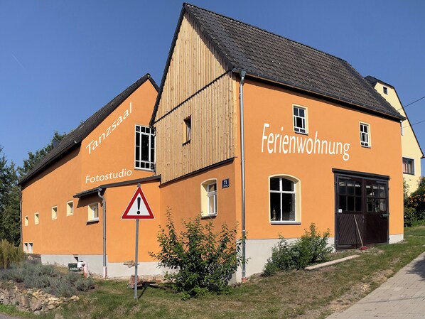 Un edificio de dos plantas con un letrero que dice 'Ferienwohnung' y 'Fotosstudio'.