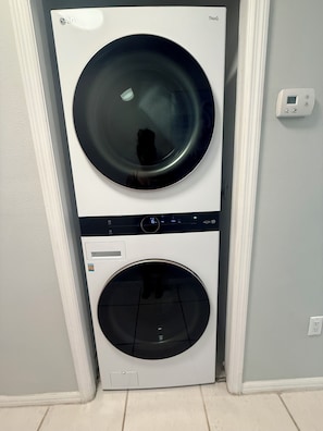 A stacked washer and dryer unit in a hallway. - Condo Beachside Villas 103A, Indian Rocks Beach w/Peek-A-Boo Ocean View & Pool! (Indian Rocks Beach)
