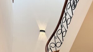 A staircase with wooden steps and a black wrought iron railing. - Sora Home - your private sky (Ho Chi Minh City)