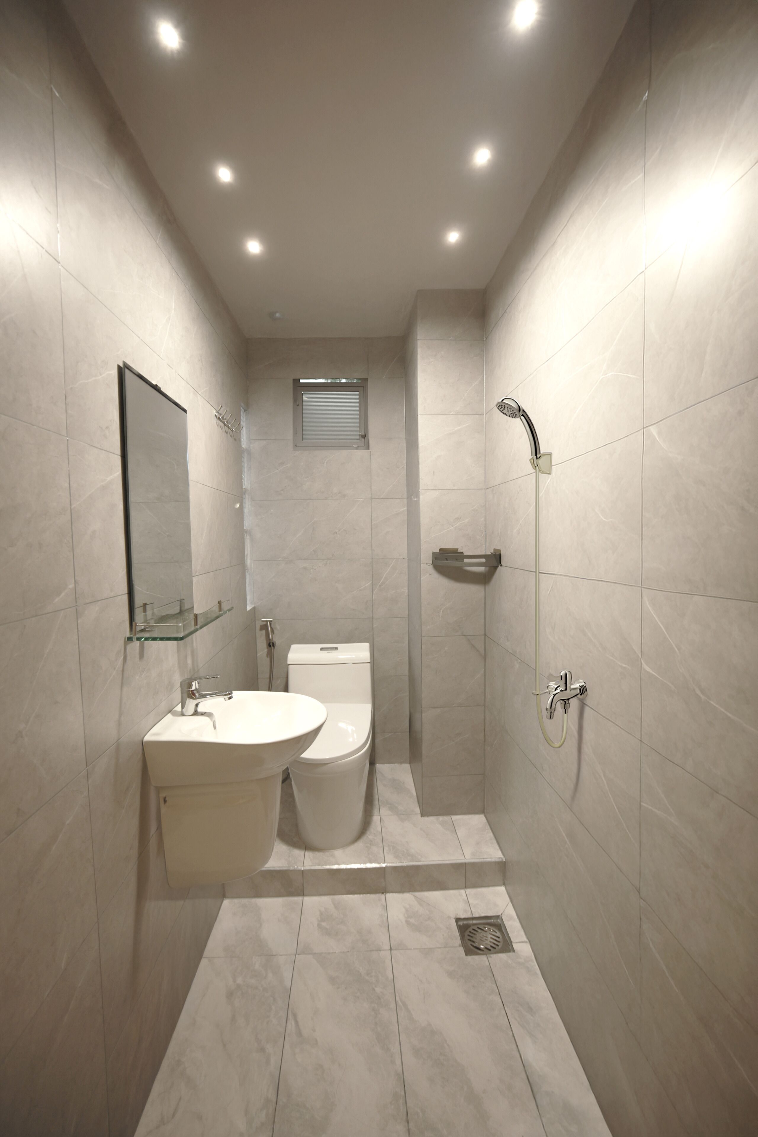 A modern bathroom with a toilet, sink, and shower.