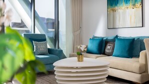 A modern living room with a sofa, a coffee table, and a painting on the wall.