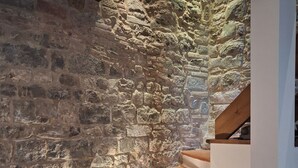 A staircase with stone walls and a lantern on the landing.