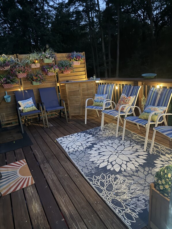 A wooden deck with outdoor seating and potted plants.
