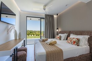 Habitación de hotel moderna con una cama grande, un escritorio y vistas a un jardín.